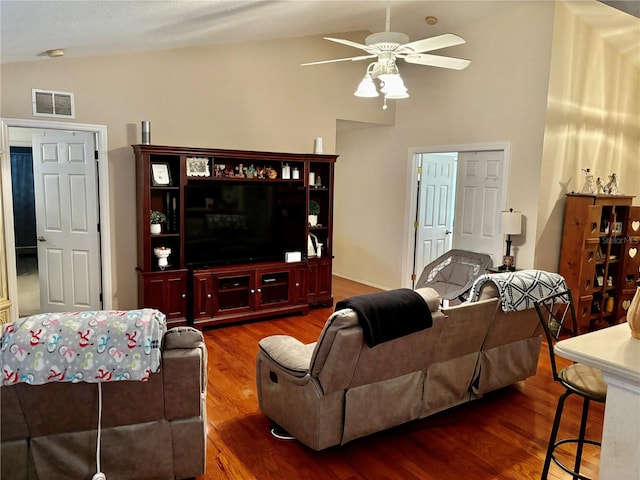 living room featuring dark hardwood / wood-style flooring, vaulted ceiling, and ceiling fan