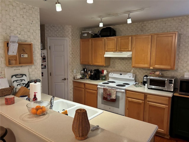 kitchen featuring sink, hanging light fixtures, track lighting, and white electric stove