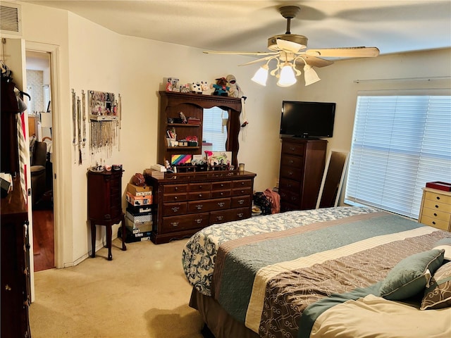 bedroom with ceiling fan and light carpet