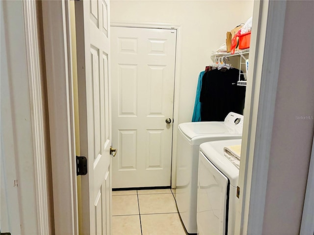 laundry room with washer and dryer and light tile patterned flooring