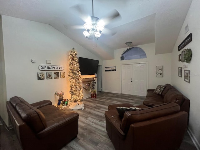 living room featuring ceiling fan, wood-type flooring, and vaulted ceiling