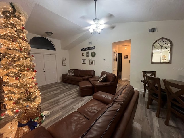 living room with hardwood / wood-style flooring, ceiling fan, and lofted ceiling