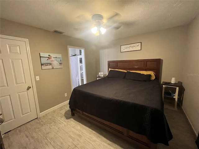 bedroom featuring ceiling fan, light wood-type flooring, and connected bathroom