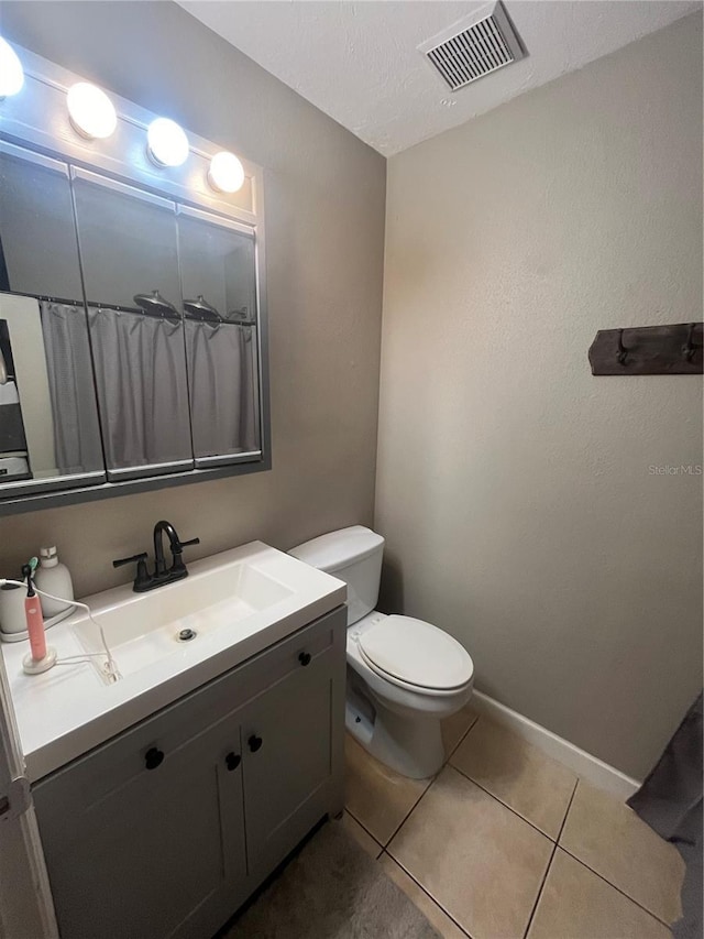 bathroom featuring tile patterned flooring, vanity, and toilet