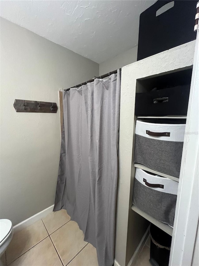 bathroom with toilet and tile patterned floors