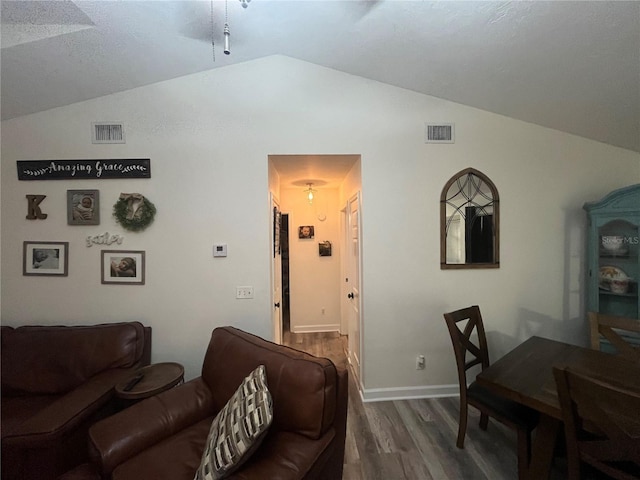 living room with dark hardwood / wood-style flooring and lofted ceiling