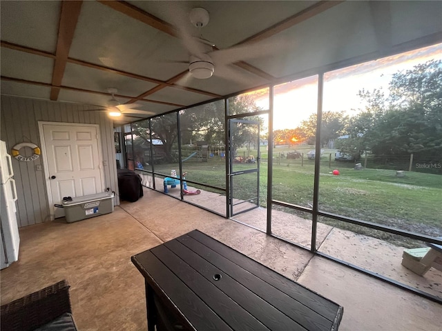 unfurnished sunroom featuring ceiling fan