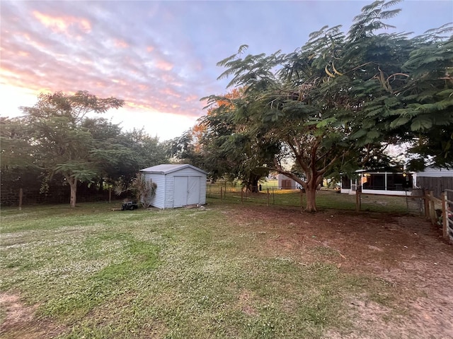 yard at dusk featuring a shed