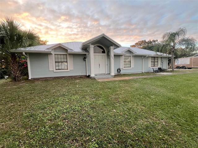 single story home featuring a lawn