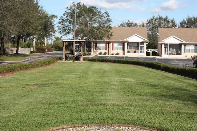 view of front of house featuring a sunroom and a front yard