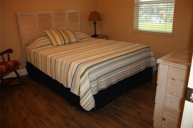 bedroom with dark hardwood / wood-style floors