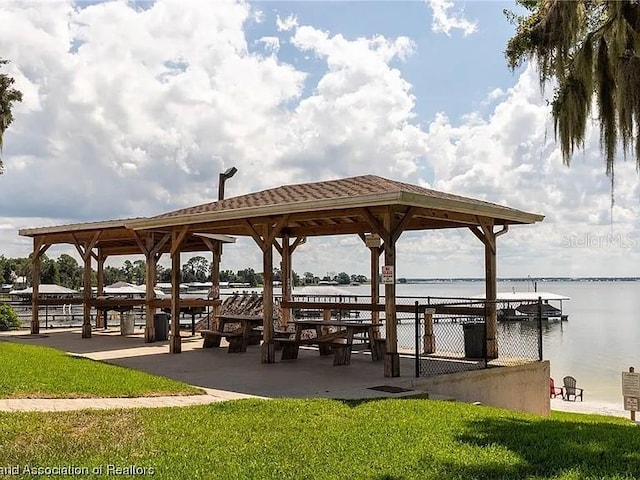 view of home's community featuring a water view and a lawn