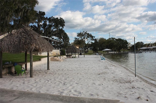 surrounding community featuring volleyball court and a water view