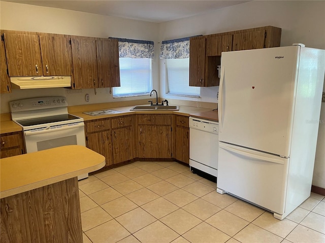 kitchen with light tile patterned floors, white appliances, sink, and range hood