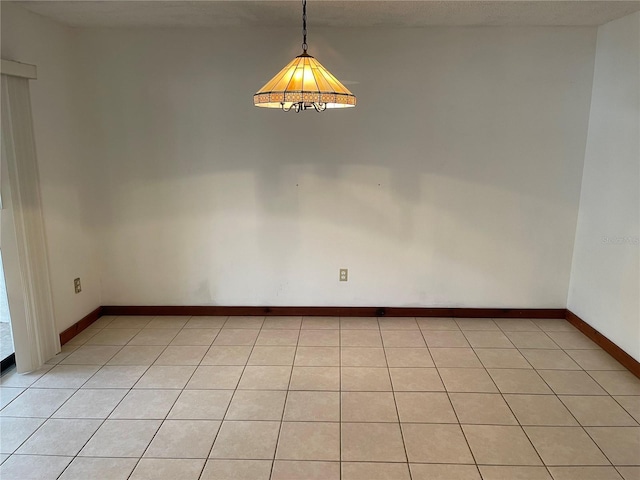 tiled empty room featuring a textured ceiling