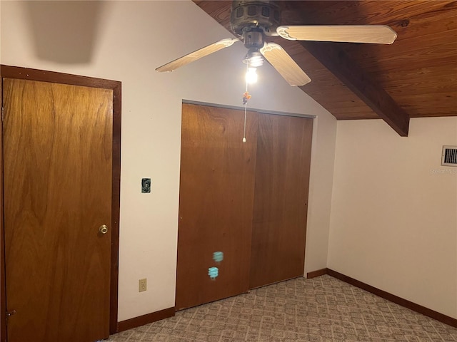 unfurnished bedroom with light colored carpet, ceiling fan, lofted ceiling with beams, wooden ceiling, and a closet