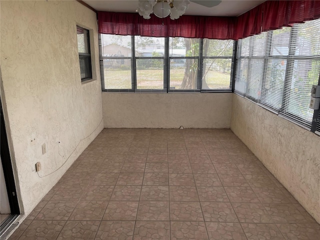 unfurnished sunroom with ceiling fan