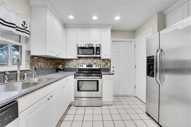 kitchen featuring backsplash, stainless steel appliances, white cabinetry, and sink