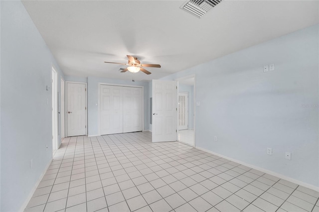 empty room featuring ceiling fan and light tile patterned floors