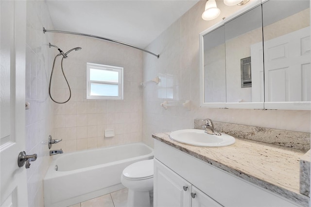 full bathroom with tile patterned flooring, vanity, tiled shower / bath combo, and toilet