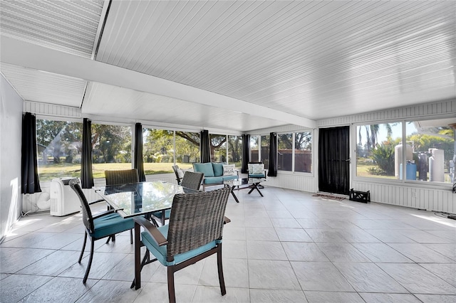 sunroom / solarium featuring an AC wall unit and a wealth of natural light