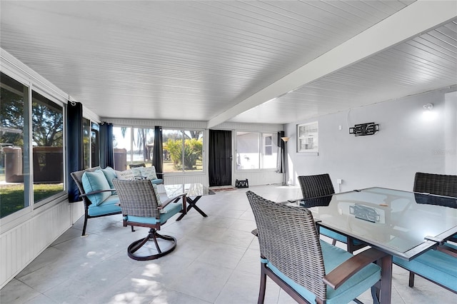 sunroom / solarium with beamed ceiling and a healthy amount of sunlight