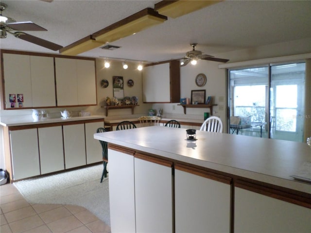 kitchen featuring light tile patterned flooring, visible vents, light countertops, and a ceiling fan