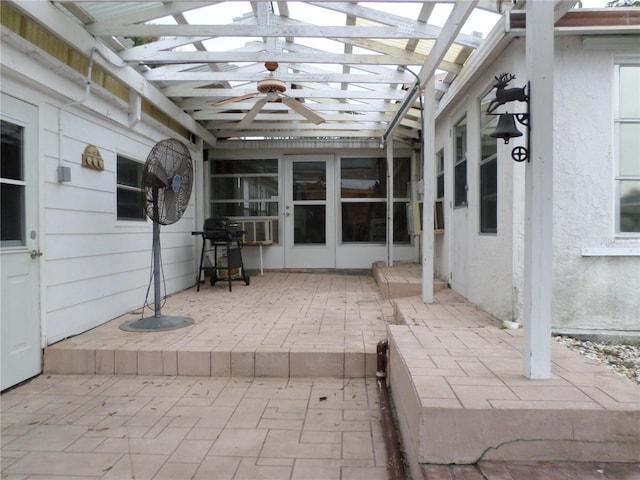 unfurnished sunroom with ceiling fan