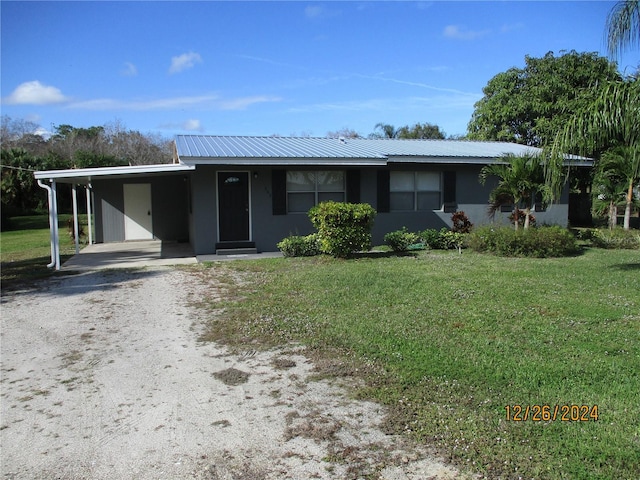 ranch-style home featuring a front yard and a carport