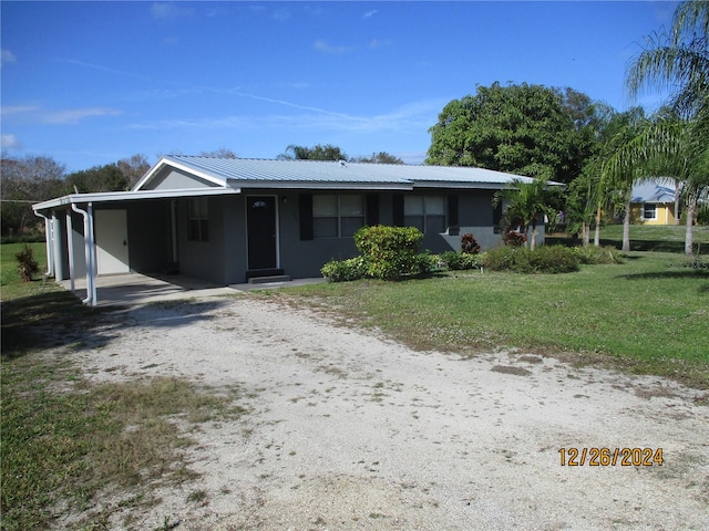 view of front of home with a carport and a front lawn