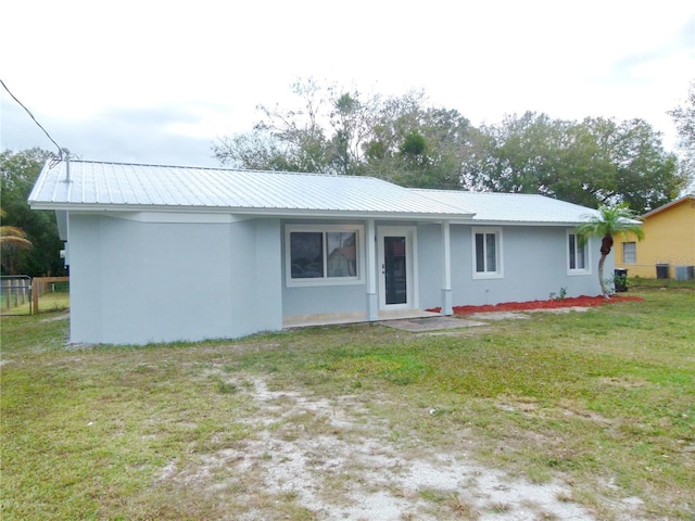 back of property featuring a lawn and central air condition unit