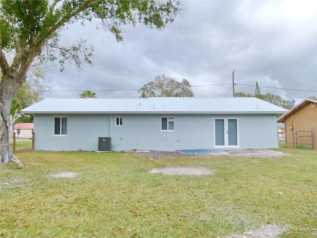 rear view of property with french doors, a yard, and central AC unit