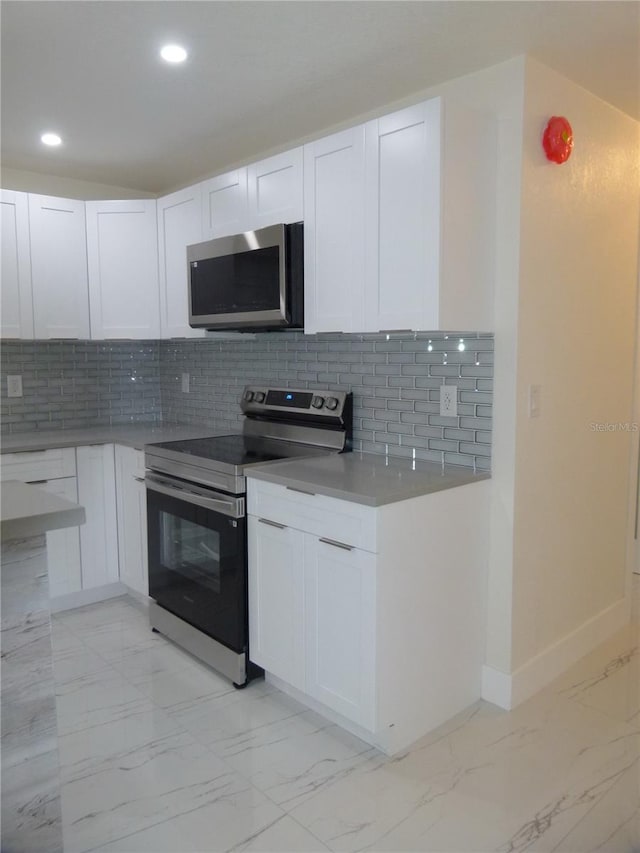 kitchen featuring decorative backsplash, white cabinetry, and appliances with stainless steel finishes