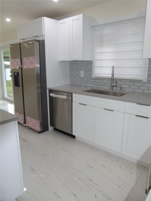 kitchen featuring sink, white cabinetry, stainless steel appliances, and tasteful backsplash