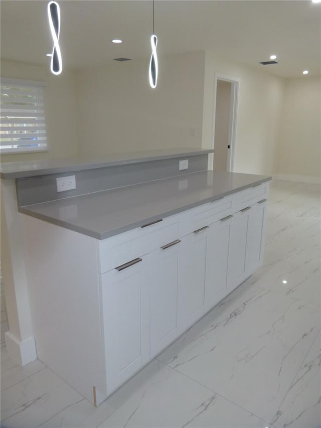 kitchen with white cabinets and hanging light fixtures