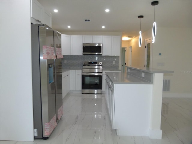 kitchen with white cabinets, decorative light fixtures, appliances with stainless steel finishes, and tasteful backsplash