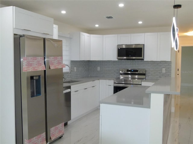 kitchen with decorative backsplash, stainless steel appliances, white cabinetry, and sink