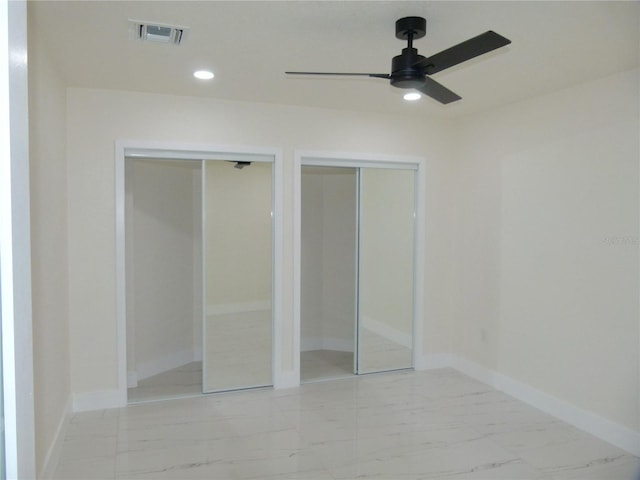 unfurnished bedroom featuring two closets and ceiling fan