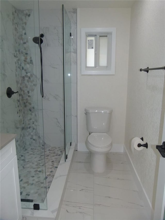 bathroom featuring a tile shower, vanity, and toilet