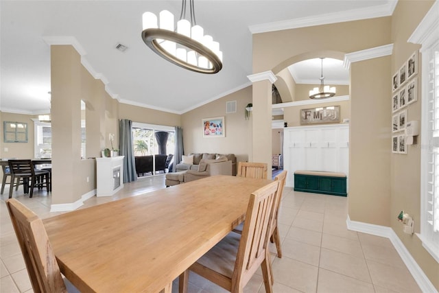 tiled dining space with a chandelier, vaulted ceiling, and ornamental molding