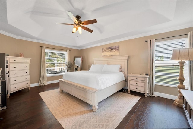 bedroom with ceiling fan, dark hardwood / wood-style floors, a raised ceiling, and ornamental molding