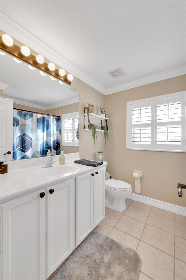 bathroom featuring tile patterned flooring, vanity, toilet, and crown molding