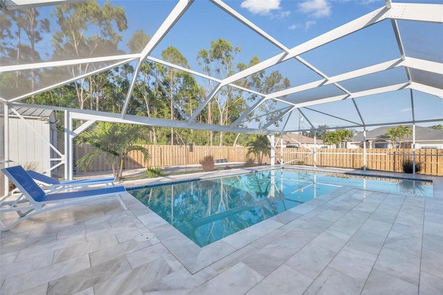 view of swimming pool featuring a patio area and a lanai