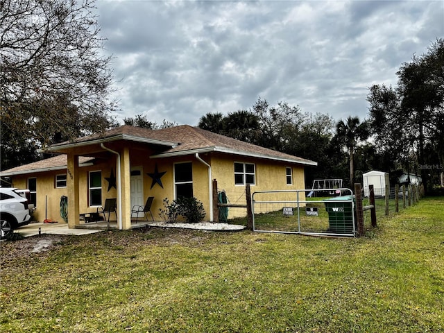 view of property exterior featuring a yard, a patio area, and a storage shed