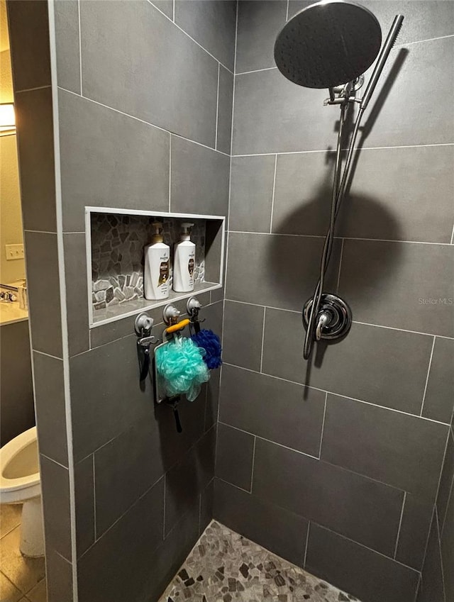 bathroom featuring a tile shower and toilet