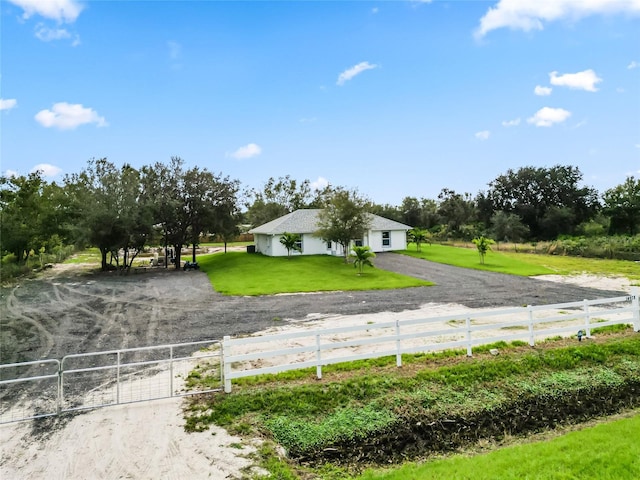 view of front of home with a front lawn and a rural view