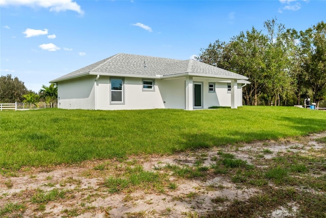 back of house with a lawn