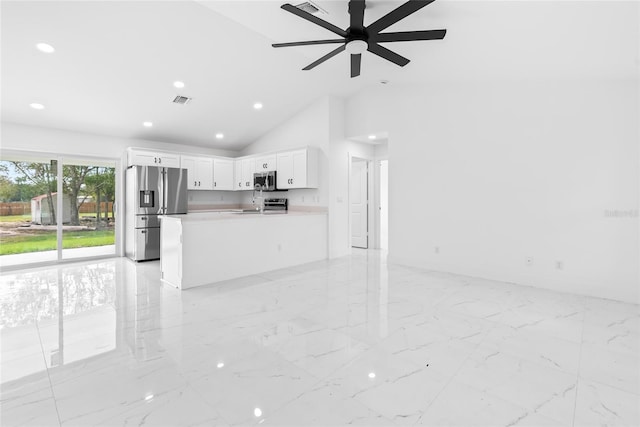 unfurnished living room with ceiling fan and high vaulted ceiling