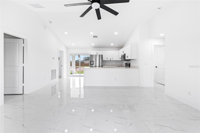 unfurnished living room with ceiling fan and high vaulted ceiling