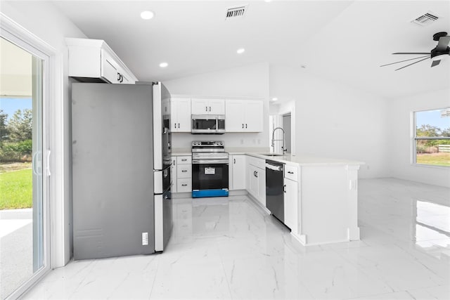 kitchen featuring kitchen peninsula, stainless steel appliances, vaulted ceiling, ceiling fan, and white cabinets